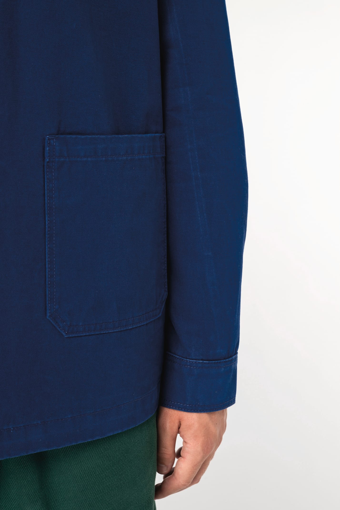 Détail d'une surchemise bleu portée par un homme