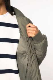 Détail d'une doudoune kaki à col teddy porté par une femme