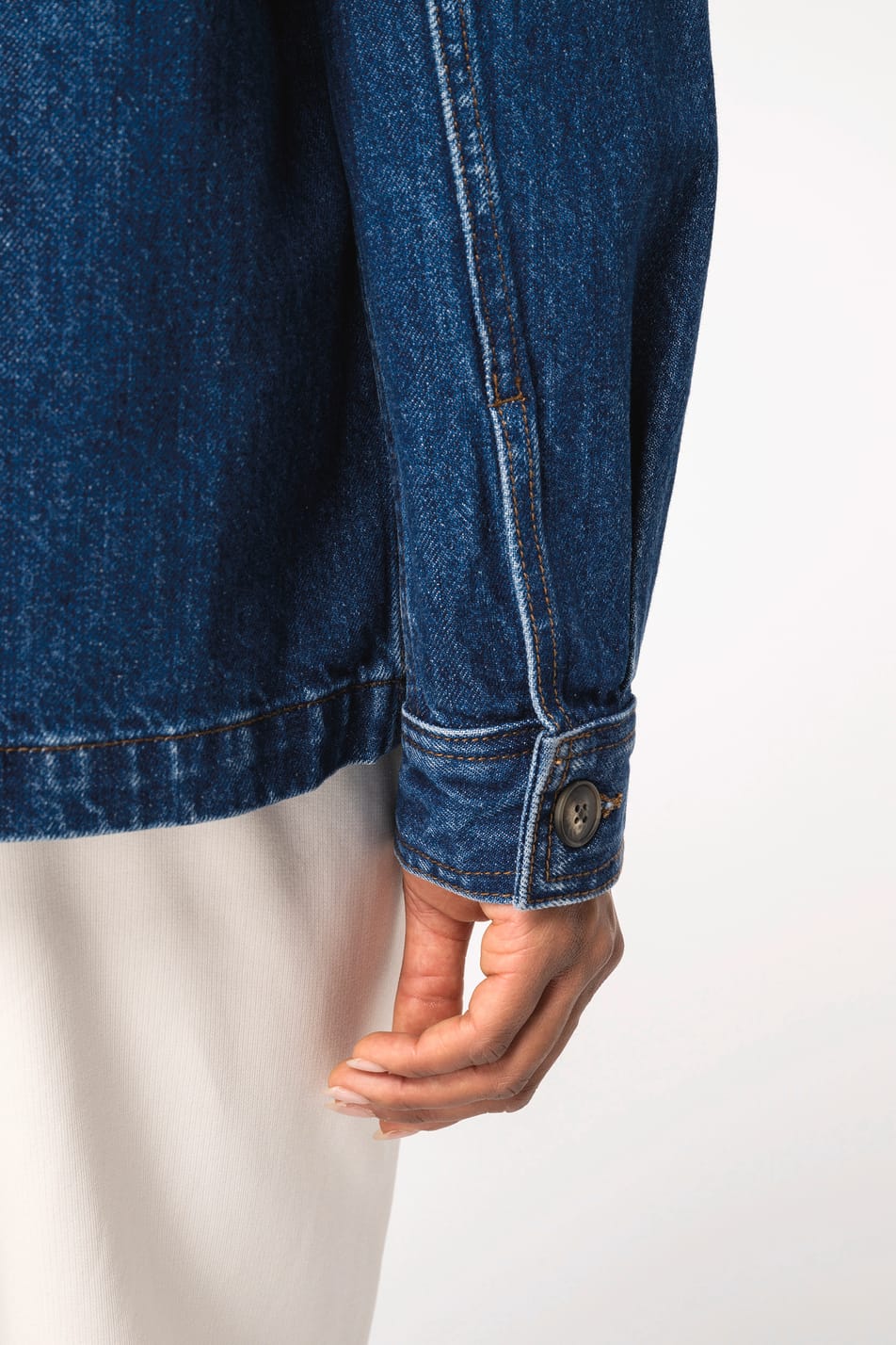 Détail de la manche d'une veste denim portée par une femme