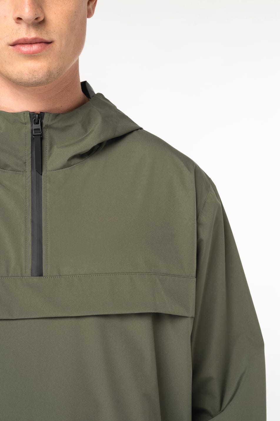 Détail d'une veste coupe-vent quart zip kaki portée par un homme