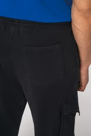 Détail de la poche arrière d'un pantalon cargo noir porté par un homme