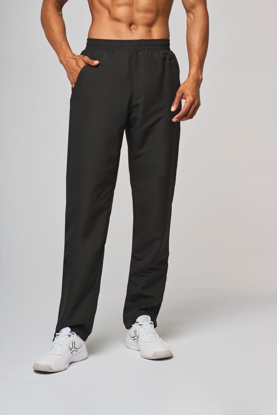Pantalon de survêtement noir porté par un homme.
