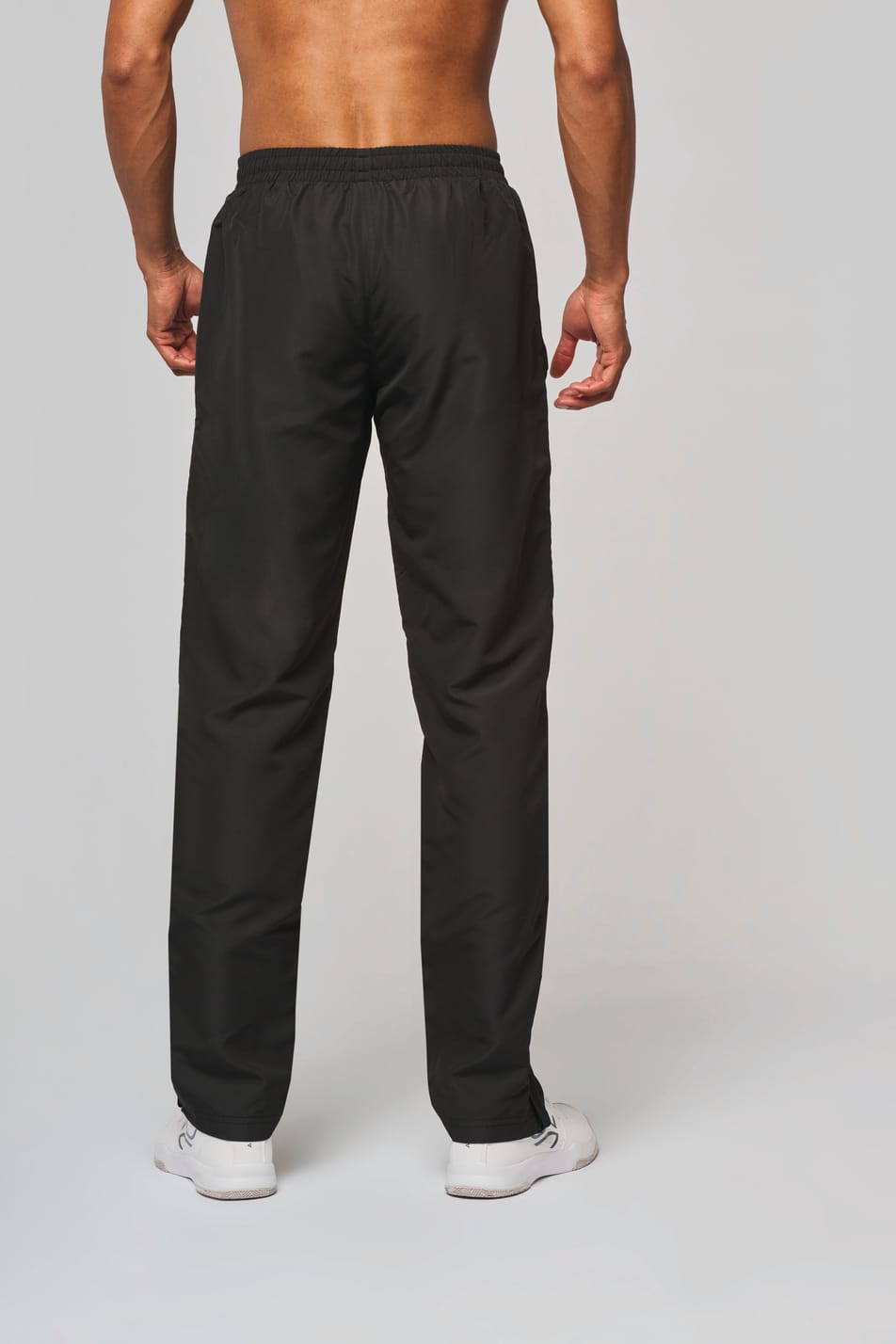 Pantalon de survêtement noir porté de dos par un homme.