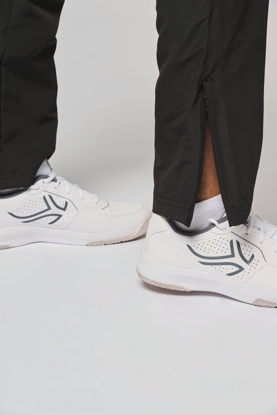 Détail bas de jambe du pantalon de survêtement noir.