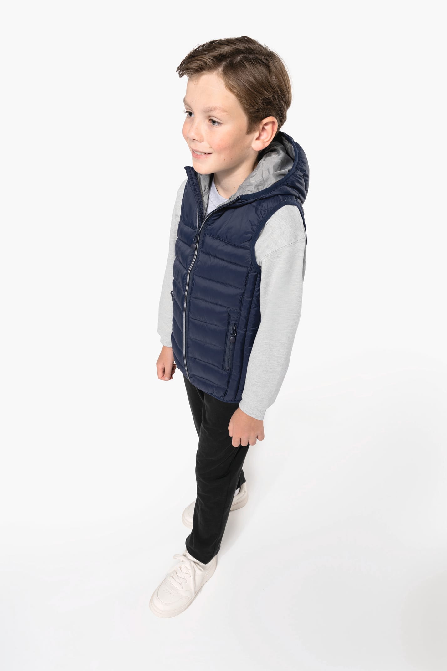 Jeune garçon châtain qui porte un bodywarmer à capuche Navy.
