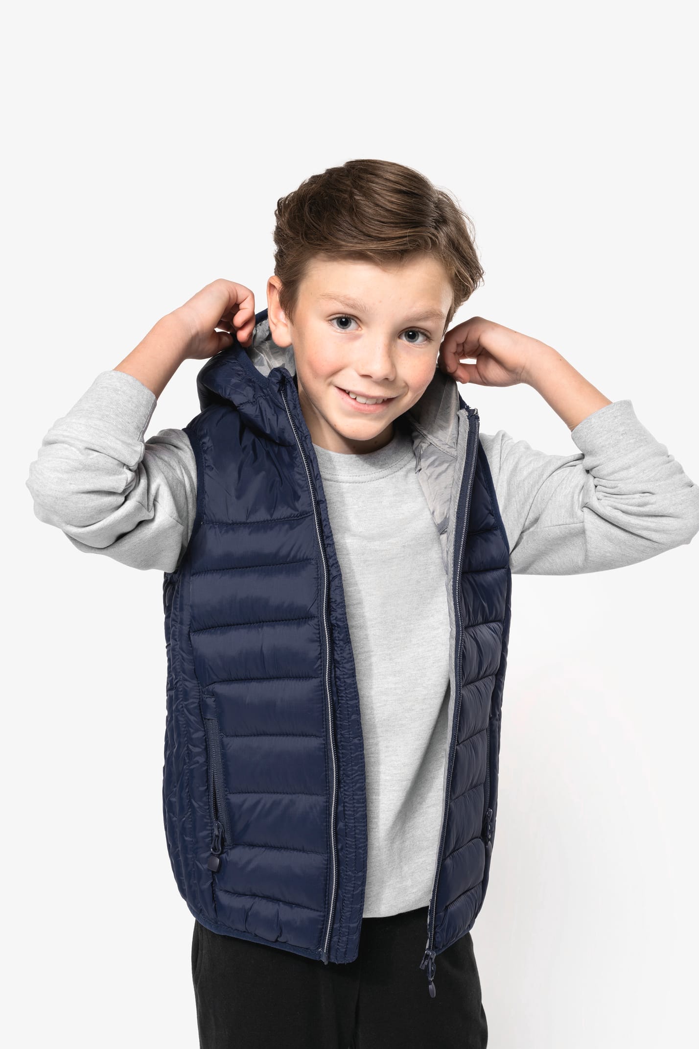 Jeune garçon châtain qui porte un bodywarmer à capuche Navy.