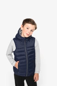Jeune garçon châtain qui porte un bodywarmer à capuche Navy.