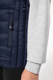 Jeune garçon châtain qui porte un bodywarmer à capuche Navy.
