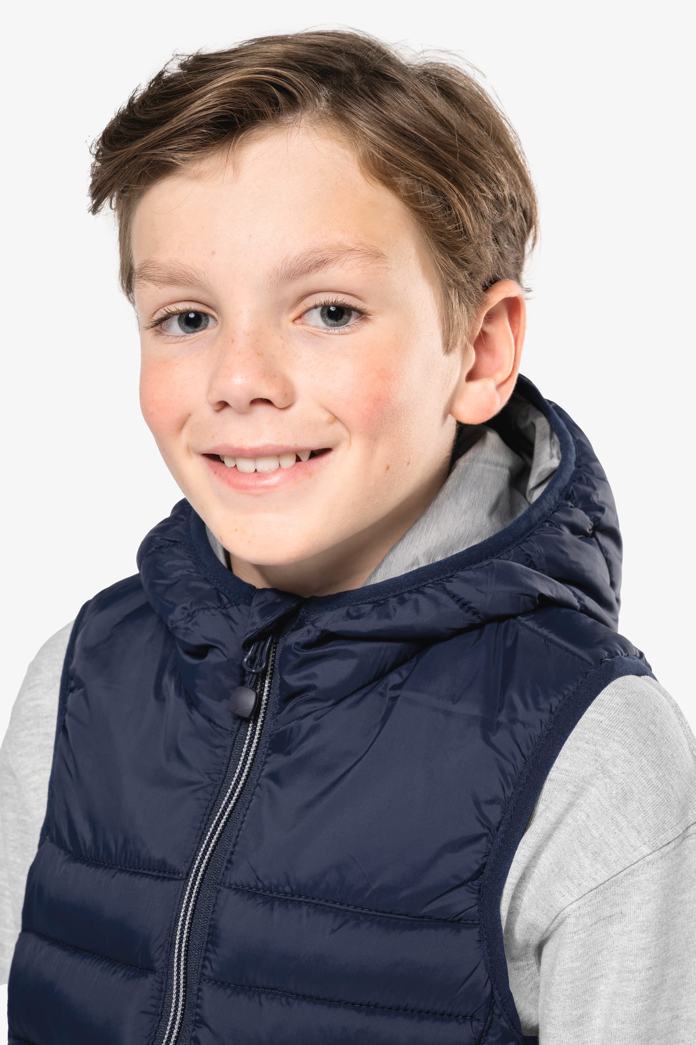 Jeune garçon châtain qui porte un bodywarmer à capuche Navy.