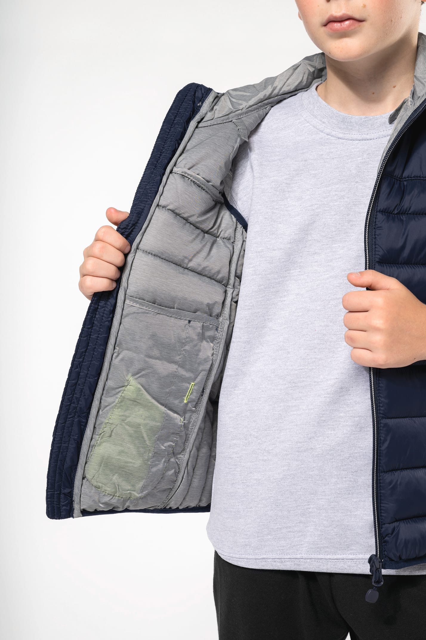 Jeune garçon châtain qui porte un bodywarmer à capuche Navy.
