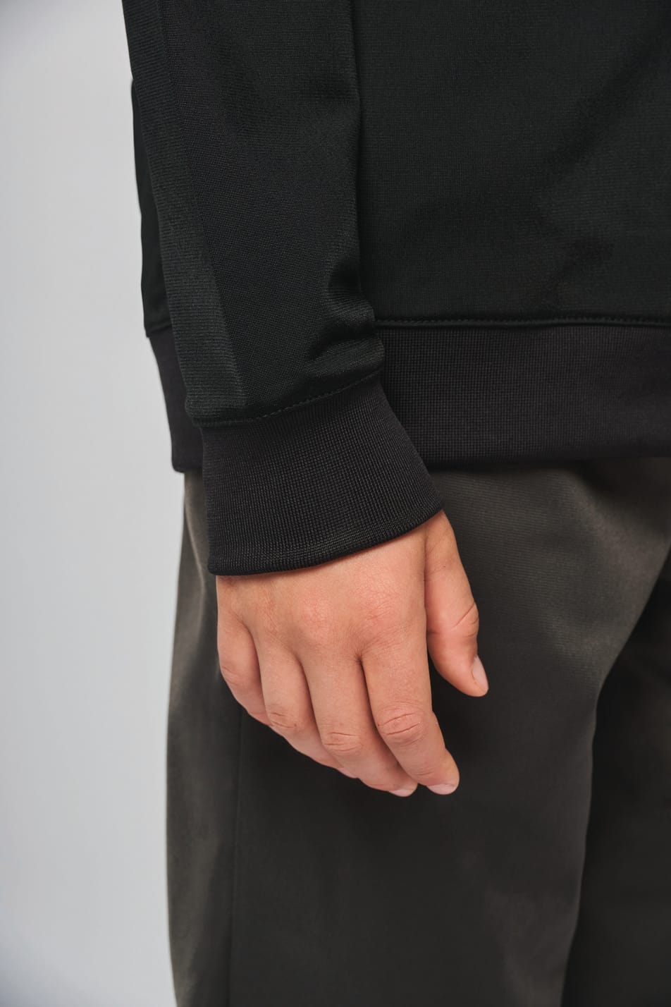 Détail bas de manche du sweat-shirt noir.