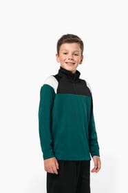 Jeune garçon qui porte une veste de survêtement zippée tricolore : verte, noire et blanche.