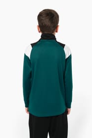 Jeune garçon qui porte une veste de survêtement zippée tricolore : verte, noire et blanche.