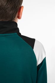 Jeune garçon qui porte une veste de survêtement zippée tricolore : verte, noire et blanche.