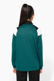 Jeune fille brune cheveux attachés qui porte une veste de survêtement zippée tricolore tendance et personnalisable : verte, noire et blanche.