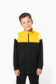Jeune garçon qui porte une veste de survêtement zippée tricolore tendance et personnalisable : jaune, noire et blanche.