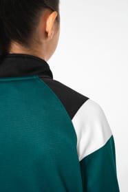 Jeune fille brune cheveux attachés qui porte une veste de survêtement zippée tricolore tendance et personnalisable : verte, noire et blanche.