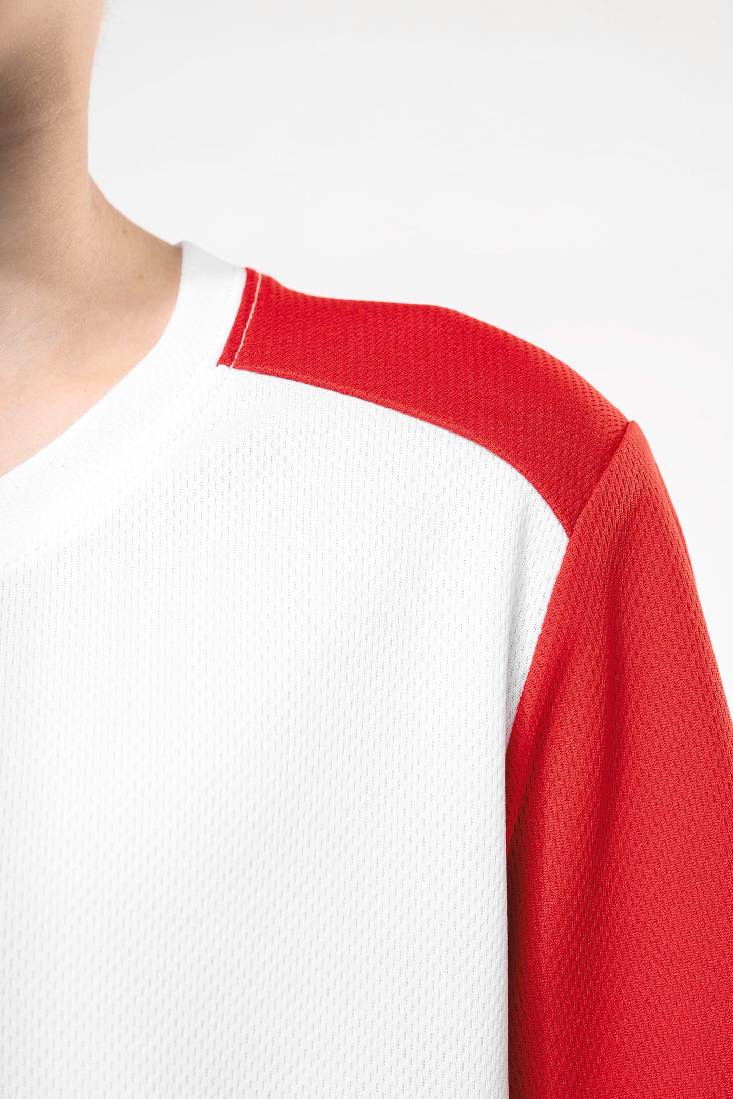 Jeune garçon cheveux courts châtain qui porte un t-shirt de sport bicolore White et Red.