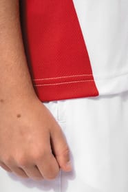 Jeune garçon cheveux courts châtain qui porte un t-shirt de sport bicolore White et Red.