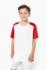 Jeune garçon châtain cheveux courts qui porte un t-shirt bicolore et un short de sport.