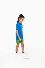 Fillette brune cheveux attachés qui porte un polo sport manches courtes Aqua Blue.