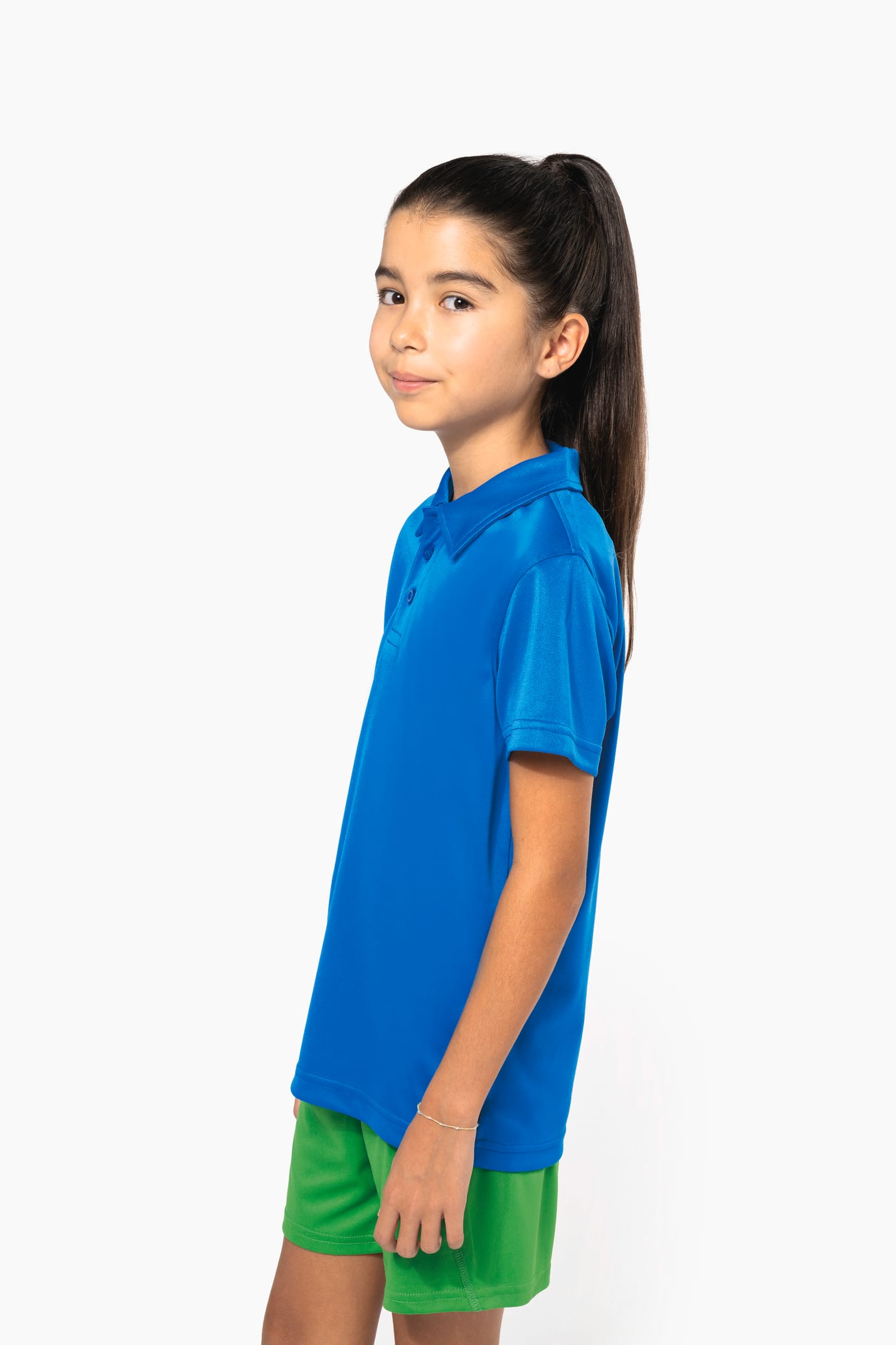 Fillette brune cheveux attachés qui porte un polo sport manches courtes Aqua Blue.