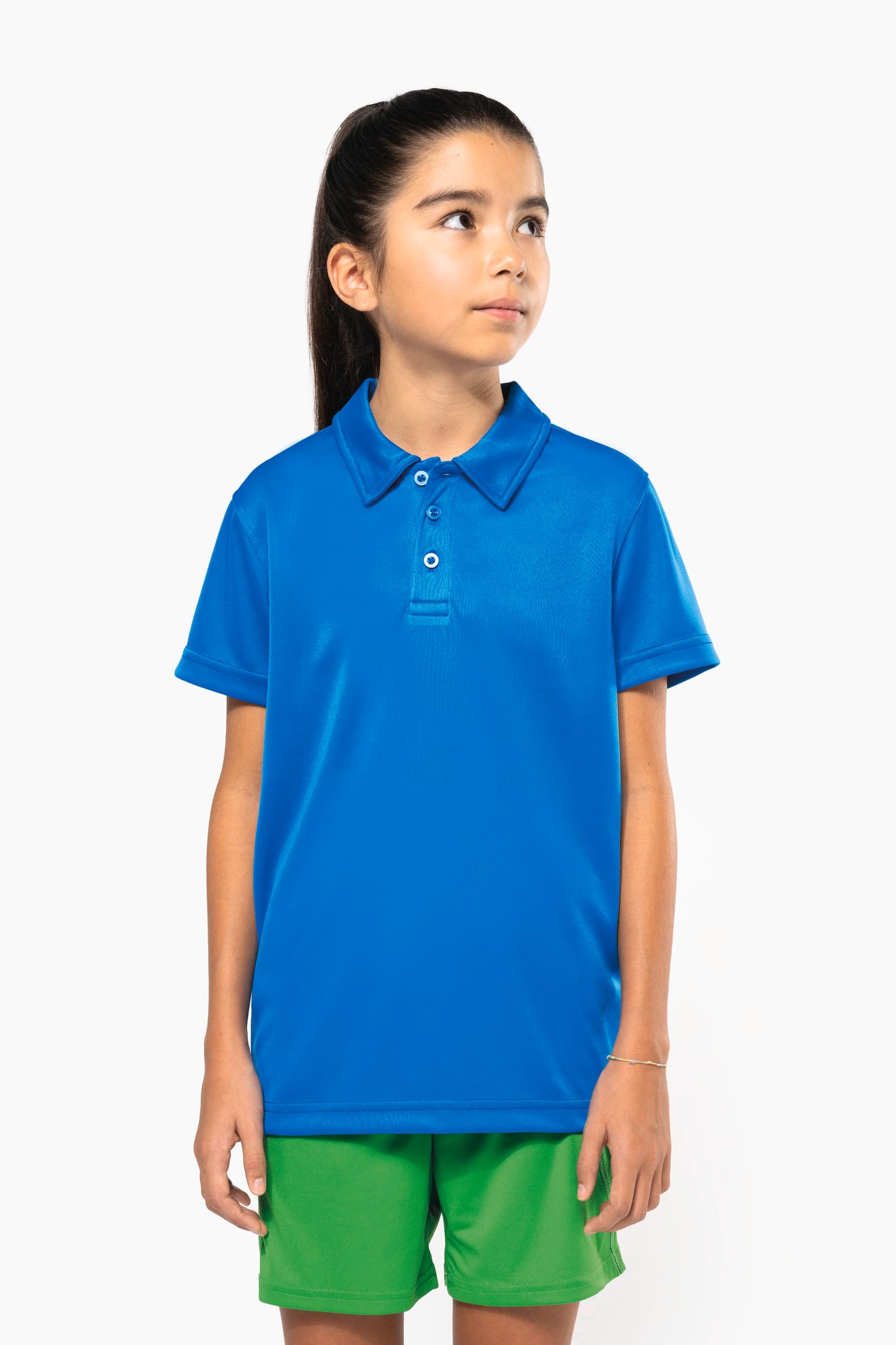 Fillette brune cheveux attachés qui porte un polo sport manches courtes Aqua Blue.