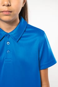 Fillette brune cheveux attachés qui porte un polo sport manches courtes Aqua Blue.