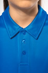 Fillette brune cheveux attachés qui porte un polo sport manches courtes Aqua Blue.