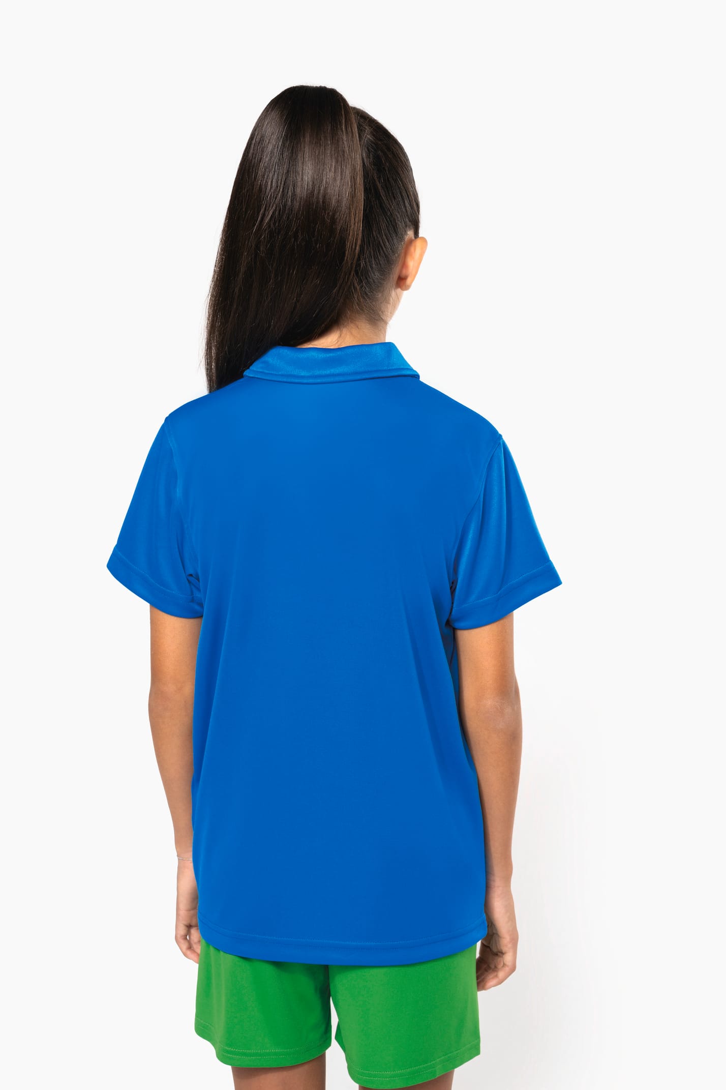 Fillette brune cheveux attachés qui porte un polo sport manches courtes Aqua Blue.
