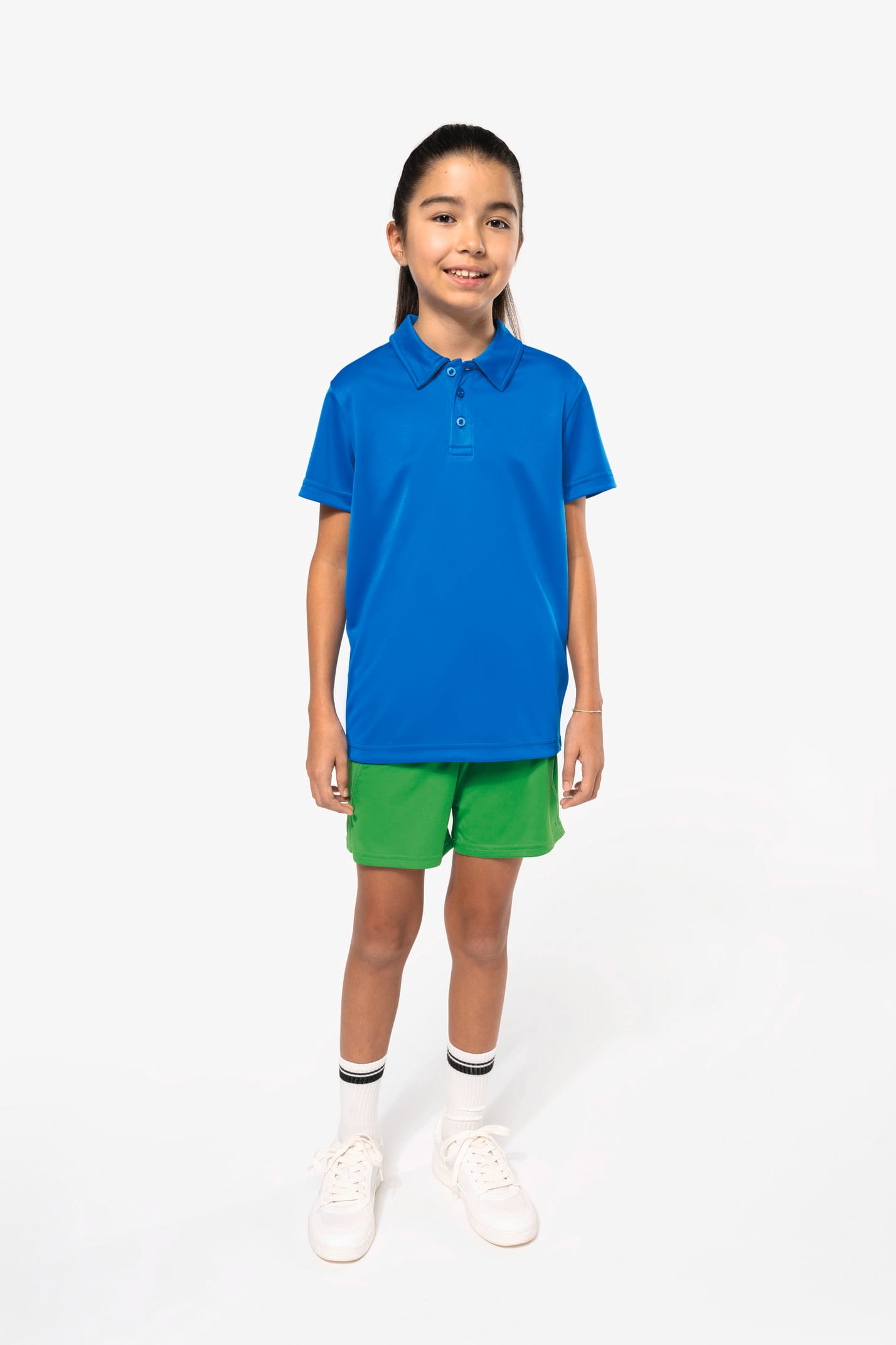 Fillette brune cheveux attachés qui porte un polo sport manches courtes Aqua Blue.