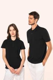Jeune femme aux cheveux châtains longs et légèrement ondulés, et jeune homme aux cheveux châtains courts portent chacun un polo noir en coton Supima® à manches courtes, sobre et élégant. Sa fibre extra-longue apporte résistance et douceur, idéale pour le 