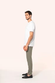 Jeune homme aux cheveux châtains courts portant un T-shirt blanc en coton Supima® col rond à manches courtes, 180 g/m². Sa coupe droite, sa construction coupée-cousue et ses finitions soignées mettent en valeur un jersey de grande finesse, au toucher doux