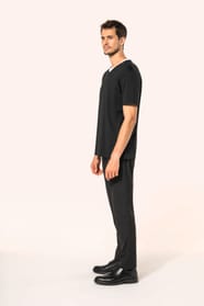 Jeune homme aux cheveux châtains courts portant un T-shirt noir à manches courtes en coton Supima® col V, coupe droite, 180 g/m². Sa fibre extra-longue apporte résistance et douceur, tandis que les finitions soignées et la construction coupée-cousue souli