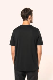 Jeune homme aux cheveux châtains courts portant un T-shirt noir à manches courtes en coton Supima® col V, coupe droite, 180 g/m². Sa fibre extra-longue apporte résistance et douceur, tandis que les finitions soignées et la construction coupée-cousue souli