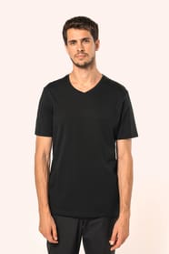 Jeune homme aux cheveux châtains courts portant un T-shirt noir à manches courtes en coton Supima® col V, coupe droite, 180 g/m². Sa fibre extra-longue apporte résistance et douceur, tandis que les finitions soignées et la construction coupée-cousue souli