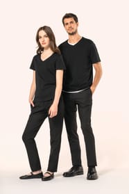 Jeune femme aux cheveux châtains longs et légèrement ondulés et jeune homme aux cheveux châtains courts portent chacun un T-shirt noir à manches courtes en coton Supima® col V, coupe droite, 180 g/m². Leur fibre extra-longue apporte résistance et douceur,
