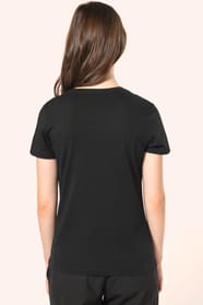 Jeune femme aux cheveux châtains longs et légèrement ondulés portant un T-shirt noir à manches courtes en coton Supima® col V, coupe droite, 180 g/m². Sa fibre extra-longue apporte résistance et douceur, tandis que les finitions soignées et la constructio