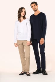 Jeune femme aux cheveux châtains longs et légèrement ondulés et jeune homme aux cheveux châtains courts portent chacun un T-shirt en coton Supima® col V, coupe droite, 180 g/m². La fibre extra-longue offre résistance et douceur, tandis que les finitions s