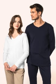 Jeune femme aux cheveux châtains longs et légèrement ondulés et jeune homme aux cheveux châtains courts portent chacun un T-shirt en coton Supima® col V, coupe droite, 180 g/m². La fibre extra-longue offre résistance et douceur, tandis que les finitions s