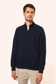Jeune homme aux cheveux châtains courts portant une veste zippée bleu marine, coupe contemporaine et confortable, 320 g/m². Son tissu bénéficie du traitement LSI (Low Shrinkage Interlock) qui garantit un faible rétrécissement. Il complète sa tenue avec un