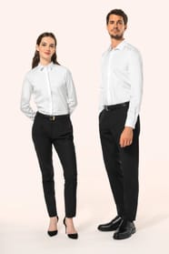 Jeune femme aux cheveux châtains longs attachés en demi-queue et jeune homme aux cheveux châtains courts portent une chemise blanche en twill à manches longues, confectionnée en coton double retors 80x2 de qualité supérieure. Leur coupe ajustée est sublim