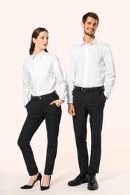 Jeune femme aux cheveux châtains longs attachés en demi-queue et jeune homme aux cheveux châtains courts portent une chemise blanche en twill à manches longues, confectionnée en coton double retors 80x2 de qualité supérieure. Leur coupe ajustée est sublim