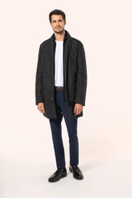 Jeune homme aux cheveux châtains courts portant un trench structuré noir à col tailleur, ouvert sur un T-shirt blanc rentré dans un pantalon de costume bleu, maintenu par une ceinture marron. Confectionné en polyester trois couches contrecollées, il assoc