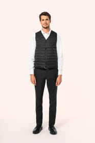 Jeune homme aux cheveux châtains courts portant un bodywarmer léger noir, conçu pour être porté seul ou sous une veste grâce à sa finesse. Réalisé en polyamide avec un rembourrage intérieur en Thinsulate™, il assure un maintien optimal de la chaleur tout 