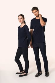 Jeune homme aux cheveux châtains courts et jeune femme aux cheveux châtains longs attachés portent chacun un jean ajusté en denim (99% coton, 1% élasthanne) à la coupe straight, confortable et moderne. Leurs finitions soignées incluent une mercerie et des