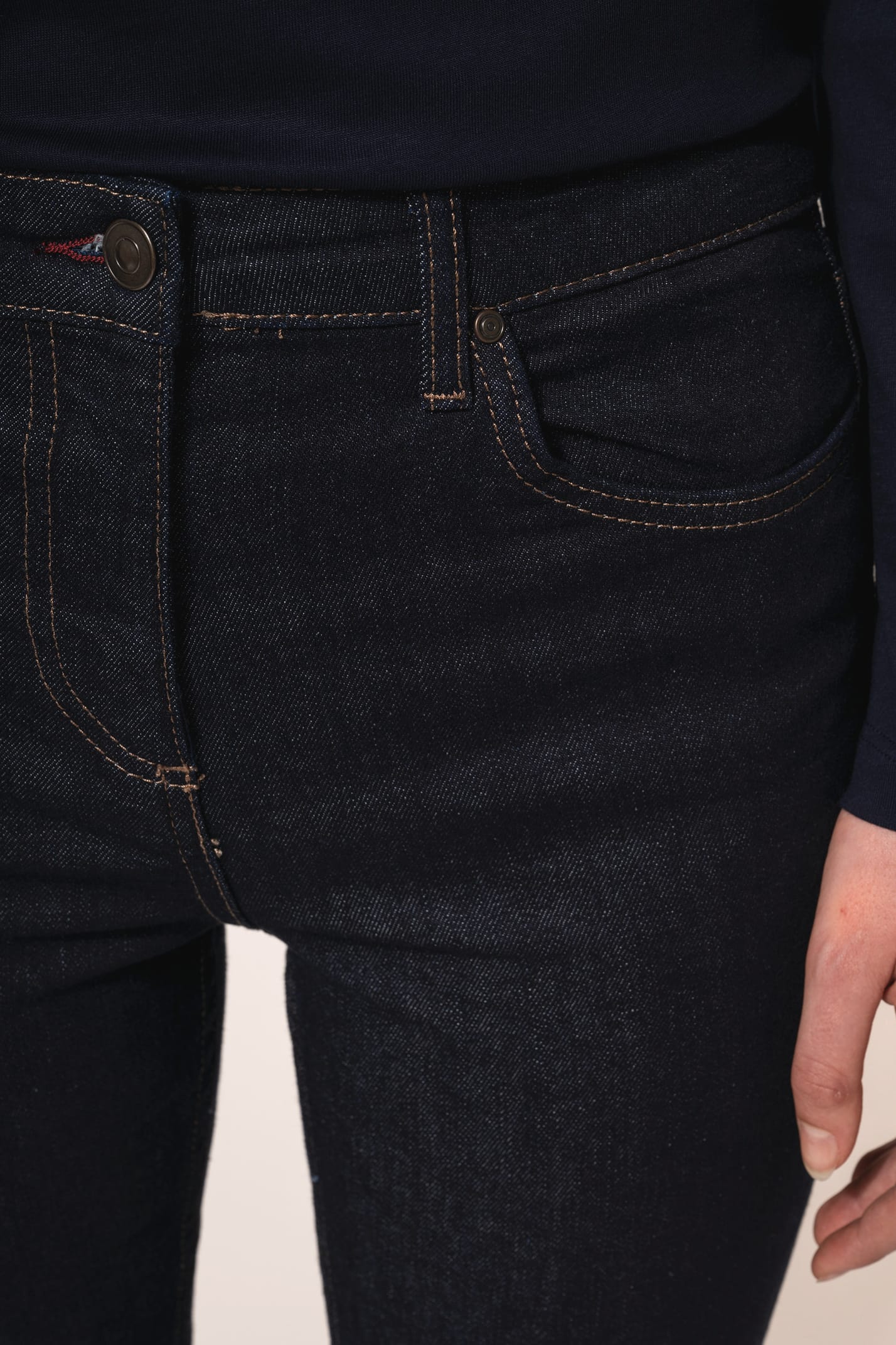 Jean ajusté en denim bleu (99% coton, 1% élasthanne) à la coupe straight, confortable et élégant. Ses finitions se distinguent par une mercerie et des rivets couleur Old Brass, des coutures contrastées bordeaux ainsi qu’une ceinture avec passants et bande