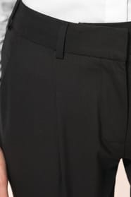 Jeune femme portant un pantalon City noir élégant, confectionné dans une matière de qualité offrant confort et tenue impeccable. Elle l’associe à une chemise blanche et à des escarpins noirs pour une silhouette raffinée et intemporelle.