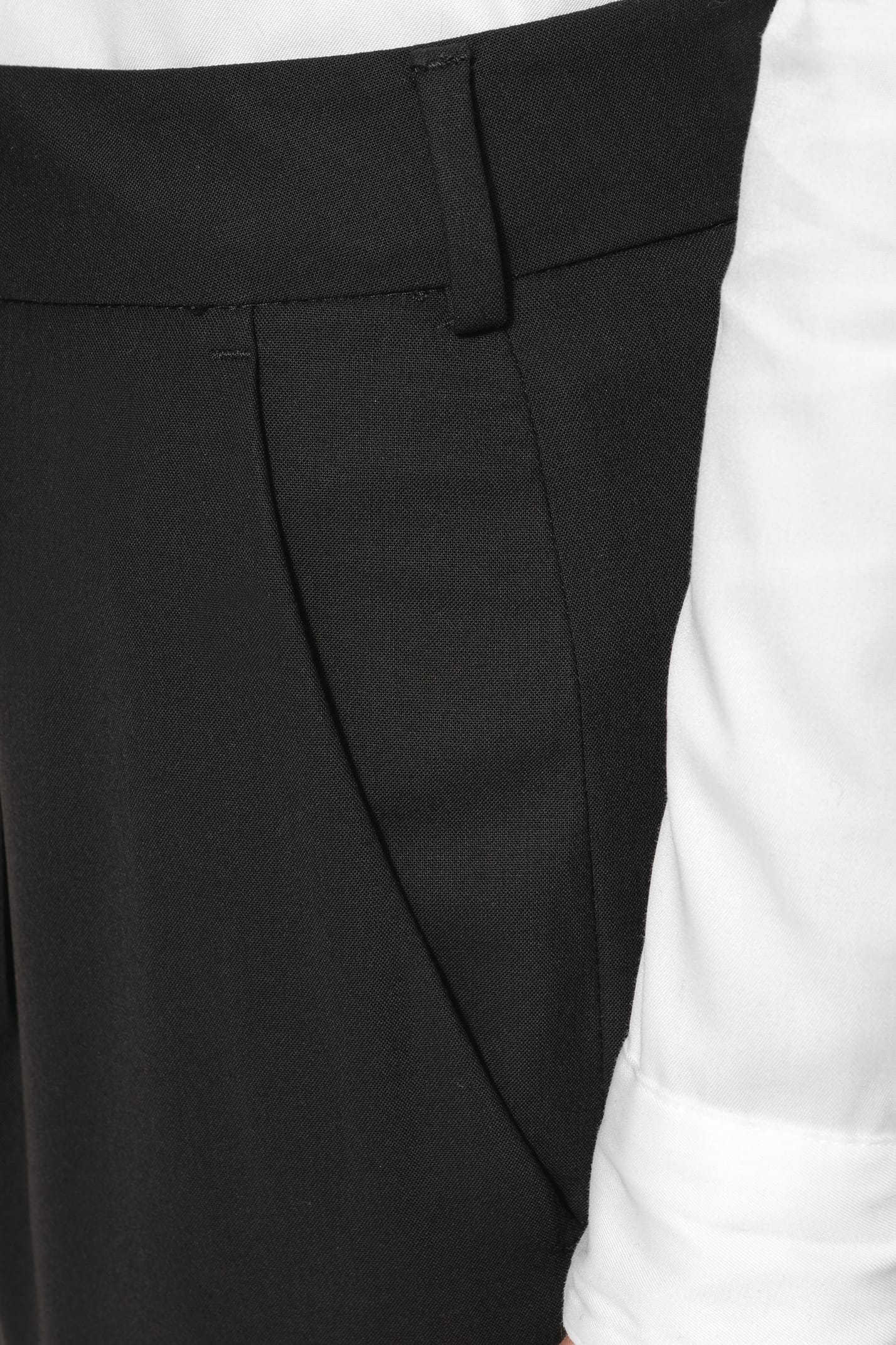 Jeune femme portant un pantalon City noir élégant, confectionné dans une matière de qualité offrant confort et tenue impeccable. Elle l’associe à une chemise blanche et à des escarpins noirs pour une silhouette raffinée et intemporelle.