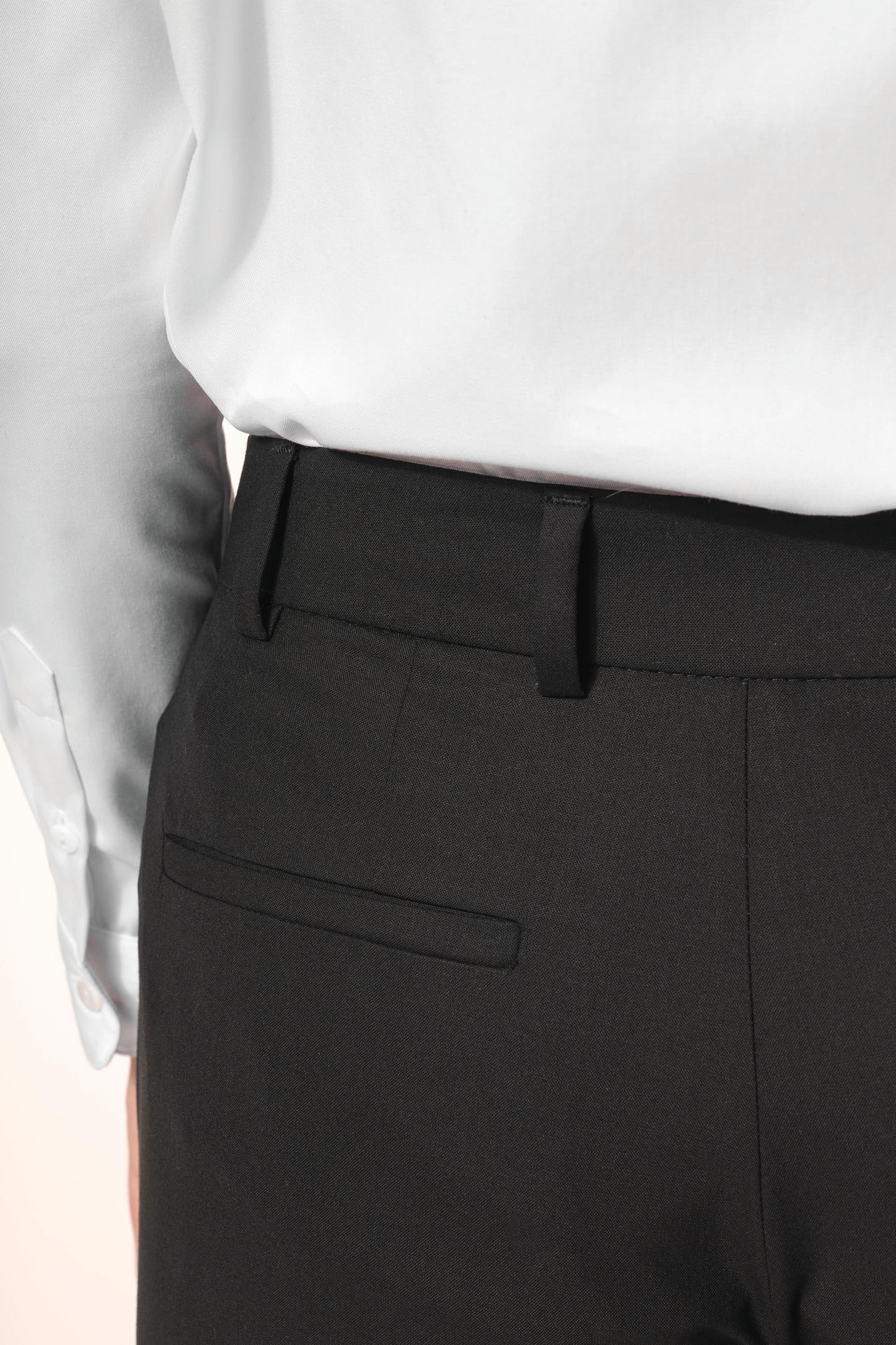 Jeune femme portant un pantalon City noir élégant, confectionné dans une matière de qualité offrant confort et tenue impeccable. Elle l’associe à une chemise blanche et à des escarpins noirs pour une silhouette raffinée et intemporelle.